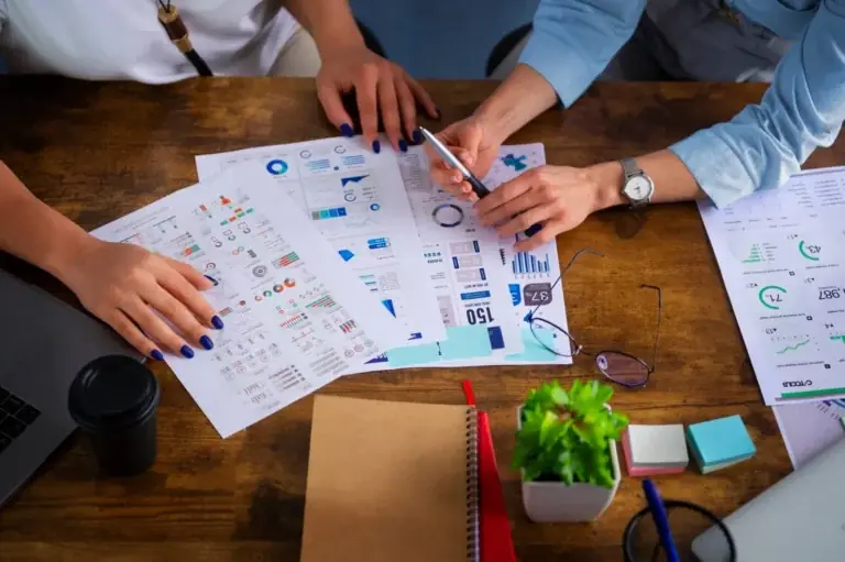 Equipo revisa informes con gráficos sobre la mesa al empezar sus servicios contables en Chile