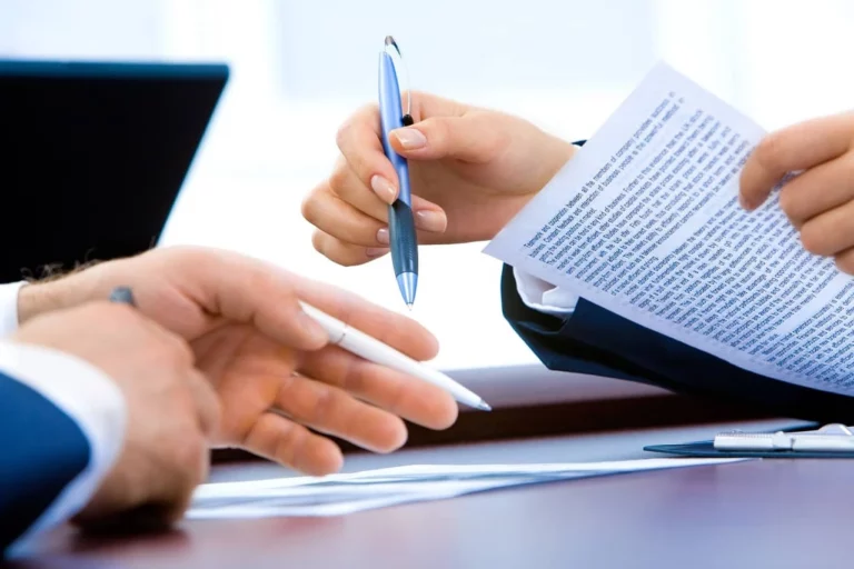 Asesor muestra un documento a su cliente en una reunión de asesoría contable y tributaria